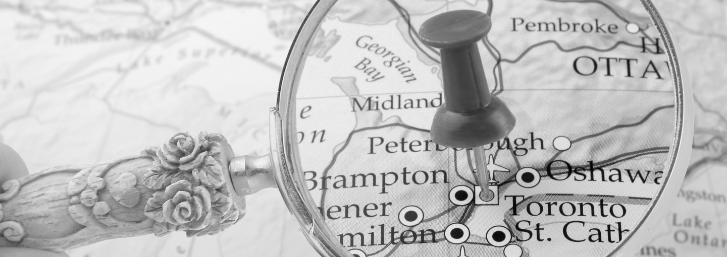 Magnifying glass showing push pin pointing to southern ontario on a map