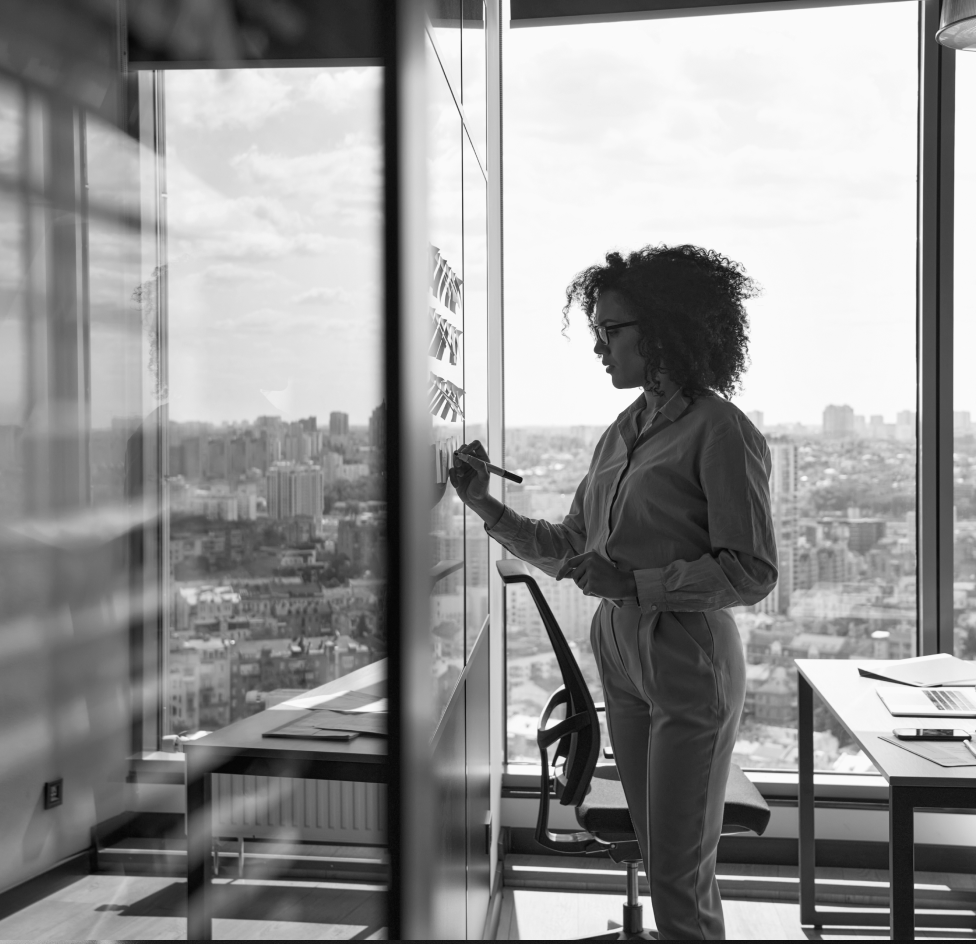 Woman writing on whiteboard in office