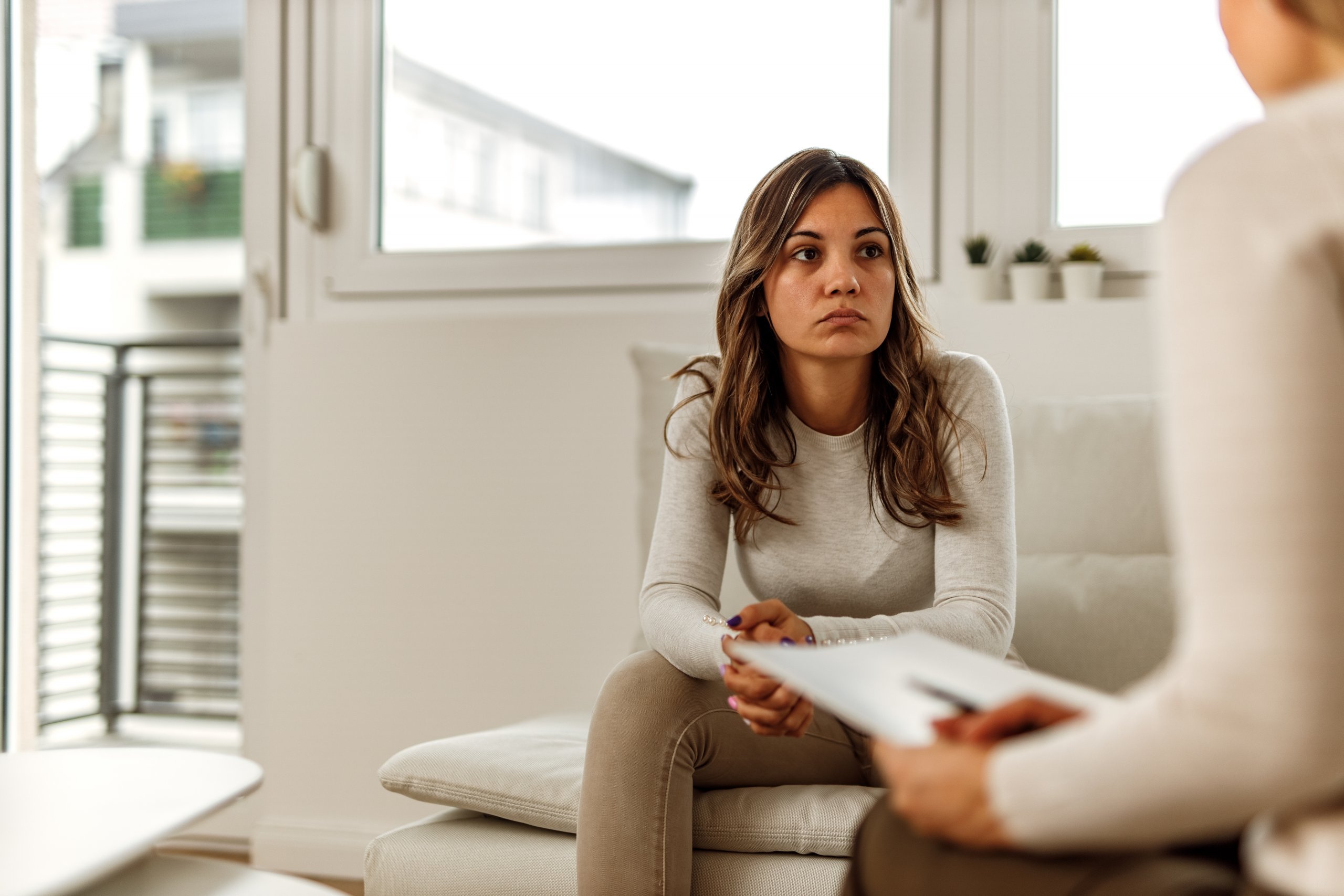 Seated woman speaking to other person